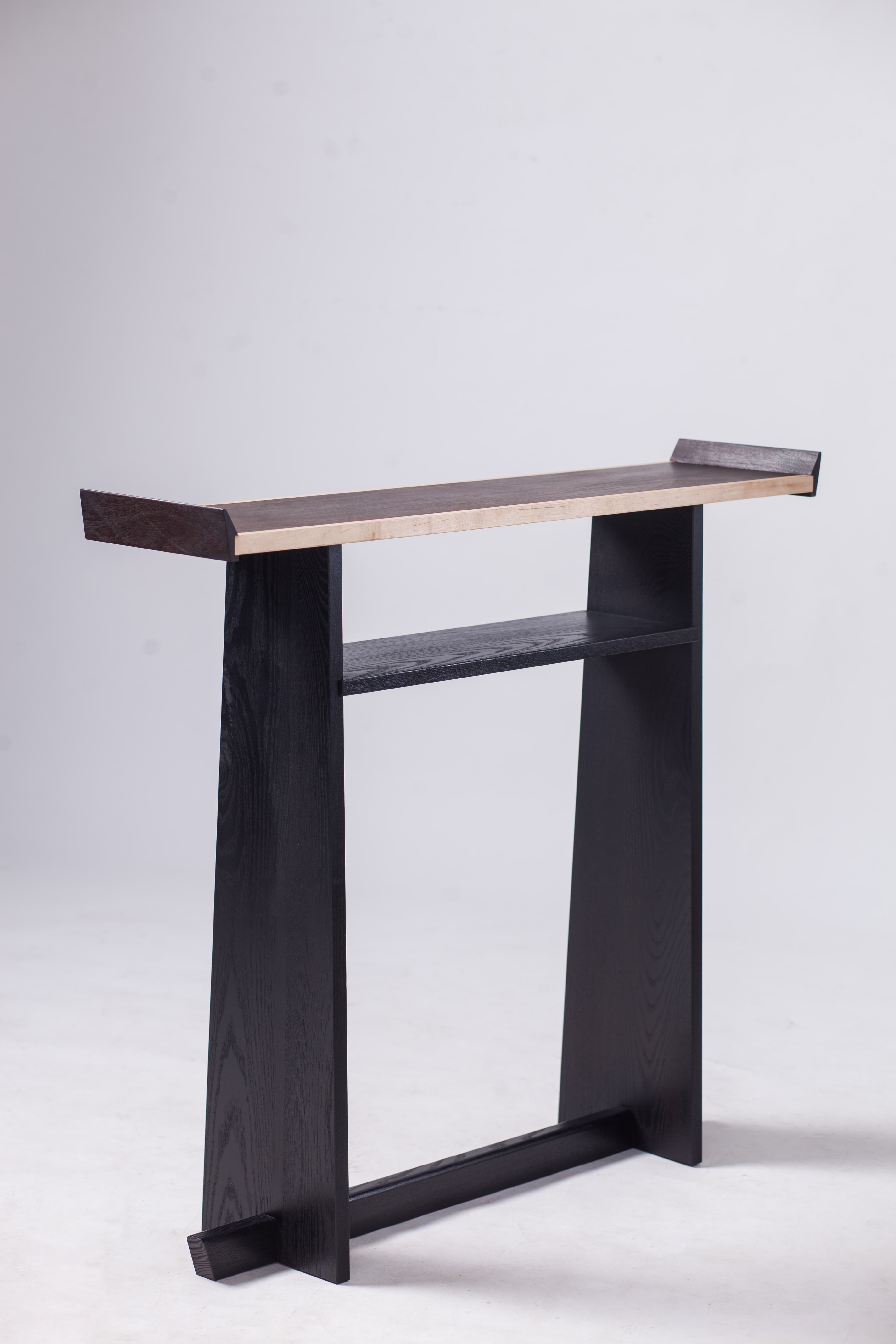 Tall dark wooden furniture piece photographed against a pale studio background.